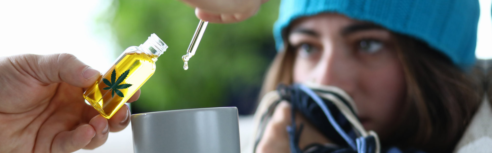 Yung woman sick with flu is dripping into cup with drops of marijuana extract closeup.