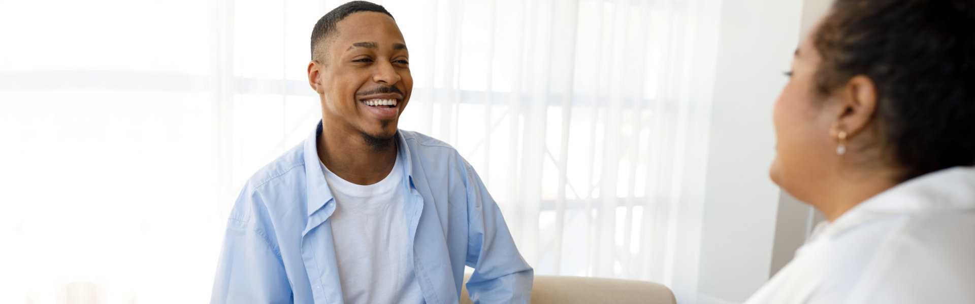 Cheerful guy smiling to young woman psychotherapist